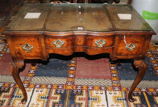 A 1930s walnut serpentine writing table, W.107cms